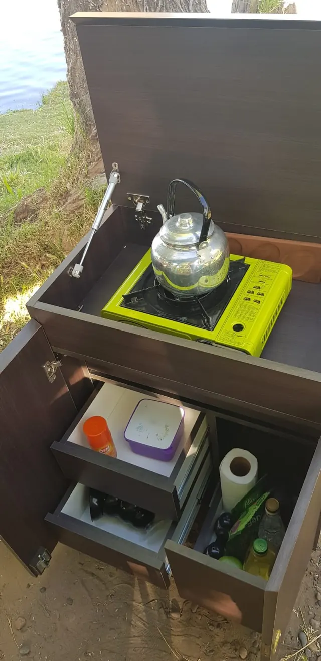 Mueble camperizado abierto con cajones y cocina portátil