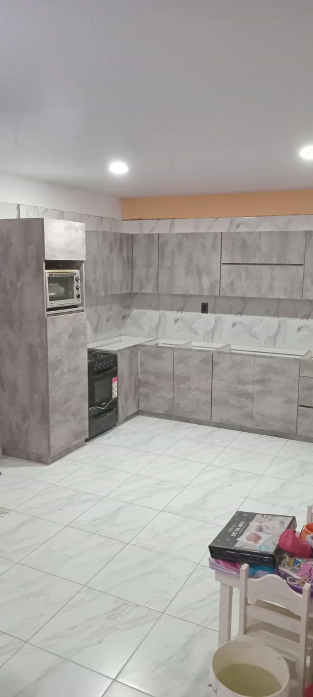 Cocina en L símil cemento con columna para horno
