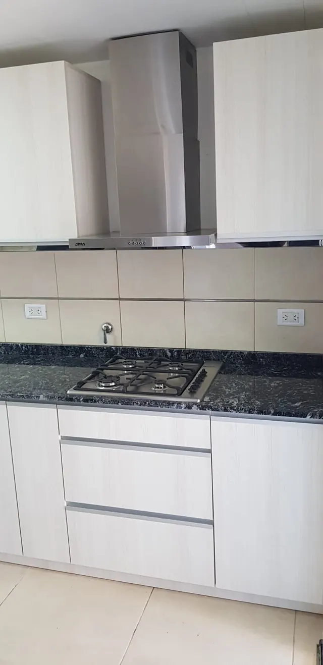 Cocina en melamina clara con campana, anafe y cajones