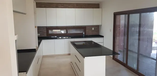 Cocina blanca con isla y mesada negra
