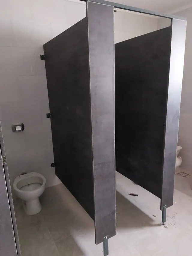 Cabina de baño con divisorio negro y símil cemento