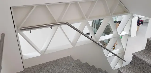 Divisorio calado blanco junto a una escalera