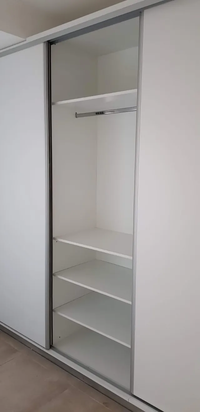 Placard corredizo con puerta de vidrio, barral y estantes blancos