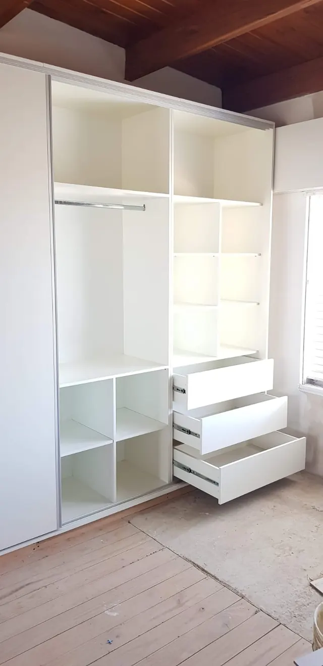 Placard blanco con módulos abiertos, cajones y puertas corredizas