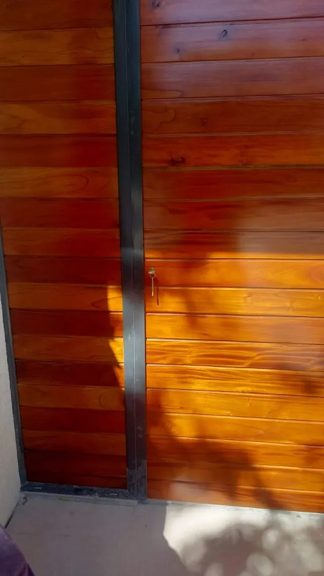 Puerta de madera con tablas horizontales y marco negro